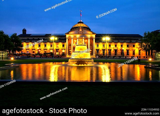 Kurhaus and Bowling Green in the evening with lights, Wiesbaden, Hesse, Germany. Wiesbaden is one of the oldest spa towns in Europe