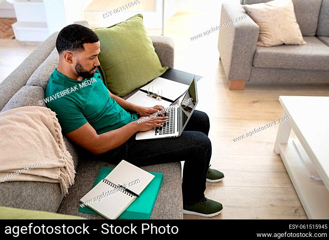 Man using laptop while sitting on couch at home