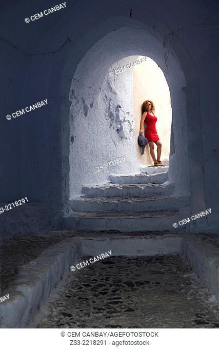 Woman posing at a passageway in Pyrgos town, Santorini, Cyclades Islands, Greek Islands, Greece, Europe