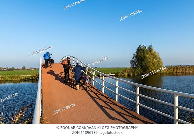 Groot-Ammers, The Netherlands - November 11, 2016: Modern architecture of a cycling bridge over a small canal at Groot-Ammers in the Netherlands
