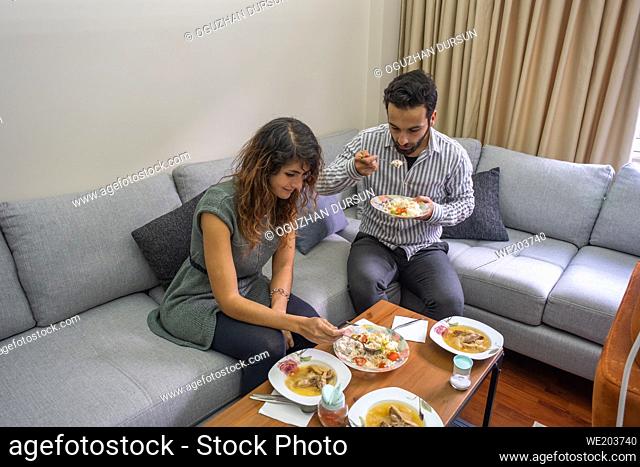 handsome man and beautiful woman have lunch in living room lifestyle concept with copy space