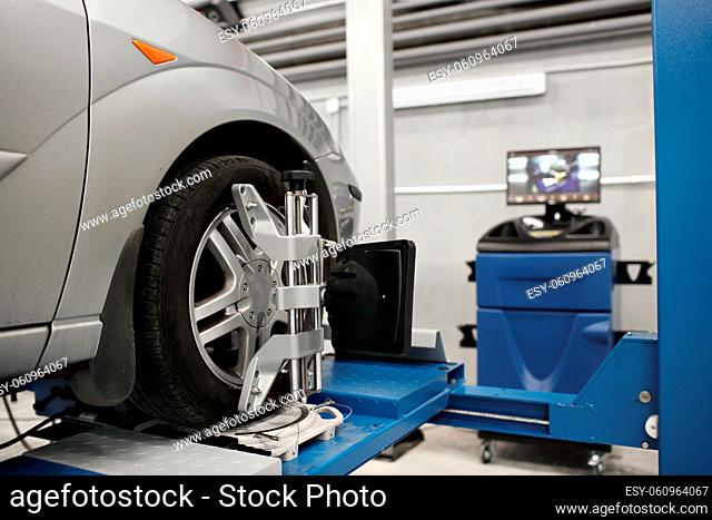 Grid sensor sets mechanic on auto. Car stand with sensors wheels for alignment camber check in workshop of Service station