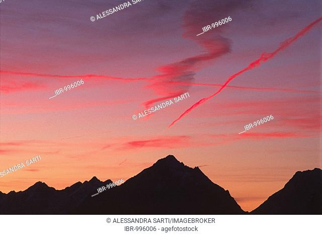 Condensation trail in the sunset abover the Vomper mountain range, Karwendel Mountains, North Tyrol, Austria, Europe