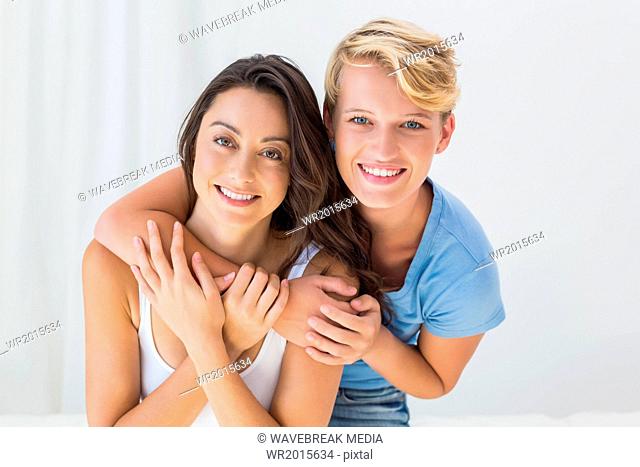 Portrait of smiling homosexual couple embracing and looking at camera