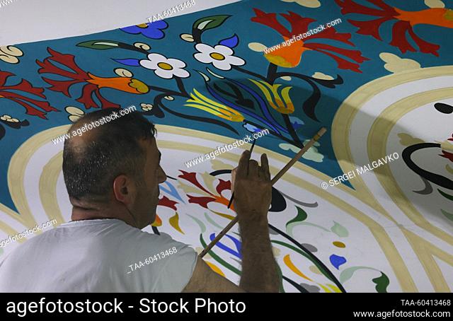 RUSSIA, SIMFEROPOL - JULY 12, 2023: An artist paints the dome of the Great Friday Mosque; artists from Russia and Turkey are taking part in the dome painting