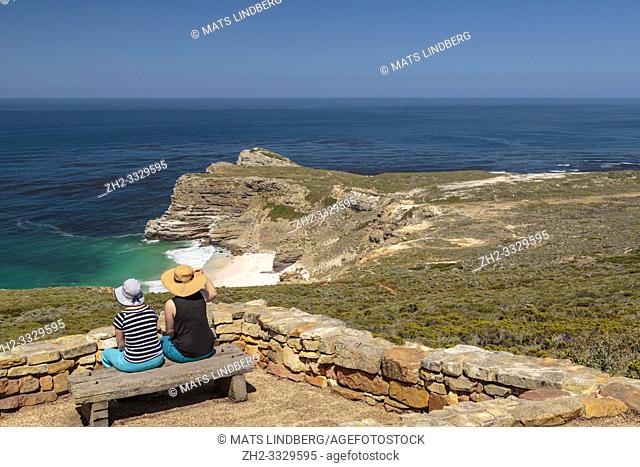 Two women sitting on a bench at cape of good hope enjoying the view over the ocean, Cape of good hope, Cape Town, South Africa