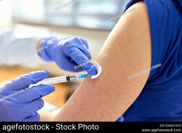 doctor with syringe vaccinating medical worker