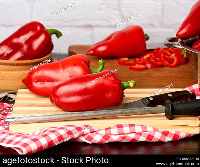 fruits of ripe red pepper on a wooden cutting board, healthy and wholesome food