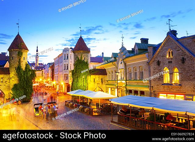Tallinn, Estonia. People Walking Near Famous Landmark Viru Gate In Street Lighting At Evening Or Night Illumination. Popular Touristic Place In Sunny Summer...