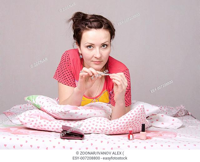 girl has manicure lying in bed