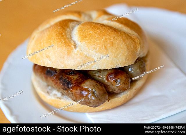 24 July 2020, Bavaria, Nuremberg: The Nuremberg bratwurst speciality ""3 im Weckla"" (three Nuremberg bratwursts in a bread roll) are on a plate