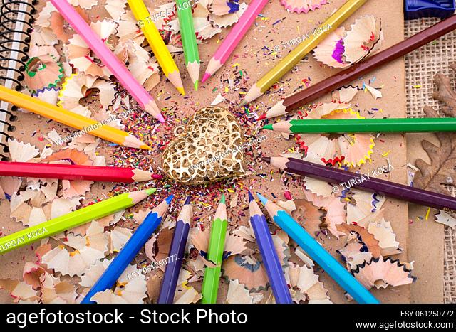 Heart shaped object amid color pencils and its shavings