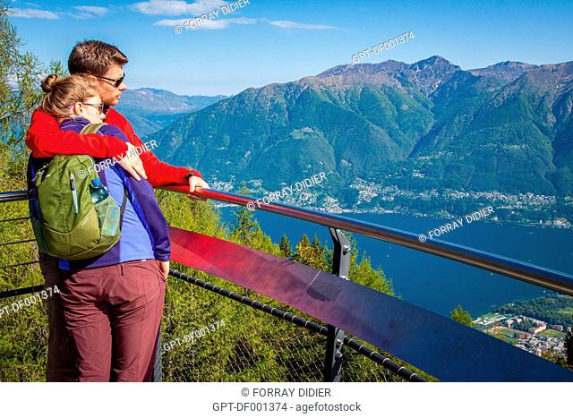 COUPLE CONTEMPLATING LAKE MAGGIORE FROM THE CARDADA VIEWPOINT ON THE HEIGHTS OF LOCARNO, CANTON OF TICINO, SWITZERLAND