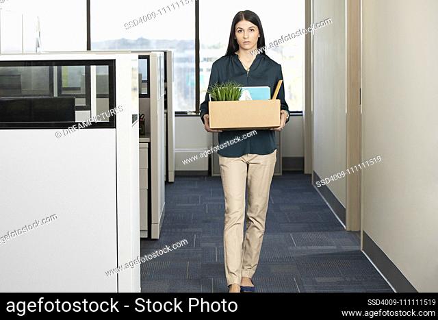 Portrait of a young woman looking into camera somberly after being laid off