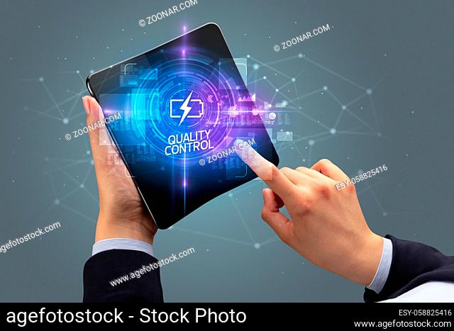 Businessman holding a foldable smartphone with CRYPTO MINING inscription, new technology concept QUALITY CONTROL