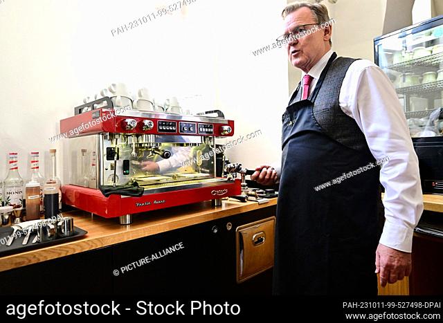 11 October 2023, Thuringia, Weimar: Bodo Ramelow (Die Linke), Prime Minister of Thuringia, stands in front of the coffee machine at the Samocca Café in Weimar