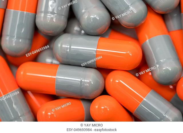 Top view of orange, grey, capsule pills