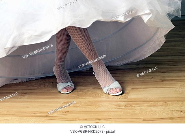 Bride in wedding dress, low section, view of legs