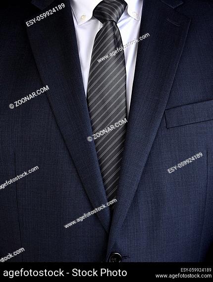 Closeup of a fashionable mens charcoal gray business suit , with white shiort and gray striped tie