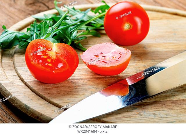 Tomatoes salad a knife on a chopping board