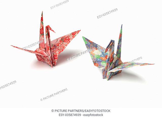 Two origami paper crane birds on white background