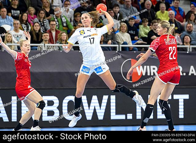 05 March 2023, Baden-Württemberg, Heidelberg: Handball, women: International match, Germany - Poland. Alicia Stolle (M) from Germany throws a ball next to...