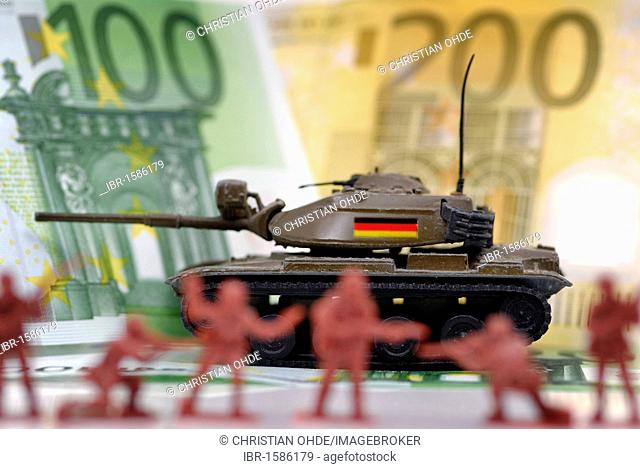 Miniature tanks with Germany flag in front of banknotes, symbolic image for German arms exports