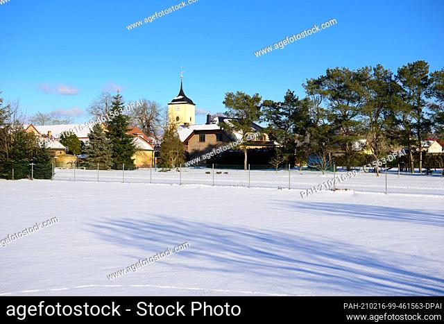 12 February 2021, Brandenburg, Schönwalde-Glien/Ot Pausin: The church in the centre of the village in the snow. The village church with a square west tower was...