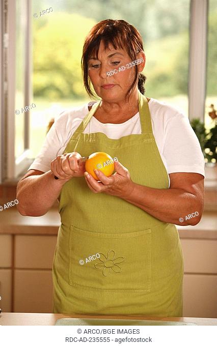 Woman with orange / knife, cutting