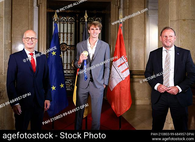 03 August 2021, Hamburg: Hamburg's mayor Peter Tschentscher (SPD, l-r), Olympic tennis champion Alexander Zverev with his gold medal and Andy Grote (SPD)
