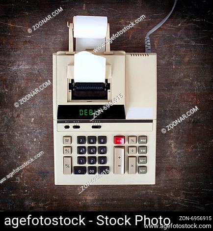 Old calculator showing a text on display - debit