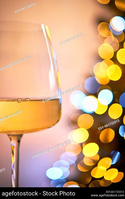 Closeup Glass of White Wine and Christmas Tree Lights