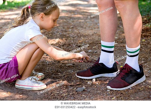 Girl tying her grandfathers shoe laces