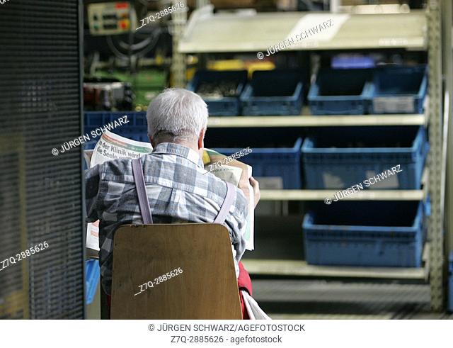 A worker reads a newspaper during a break, Cologne, Germany