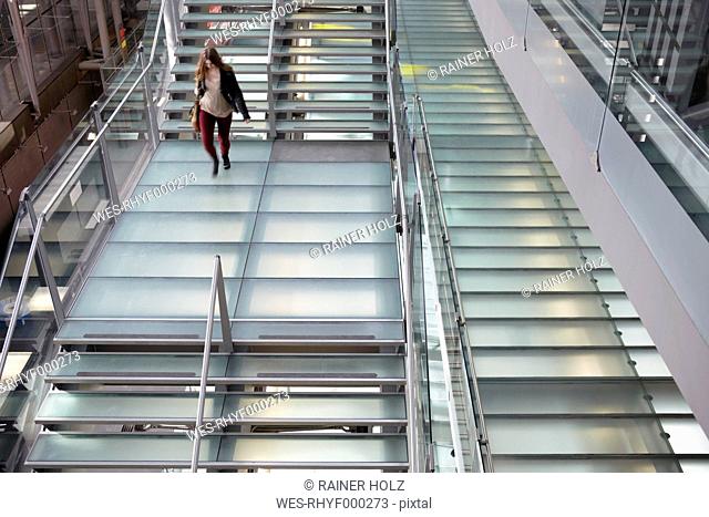 Germany, Cologne, Teenage girl walking airport stairs
