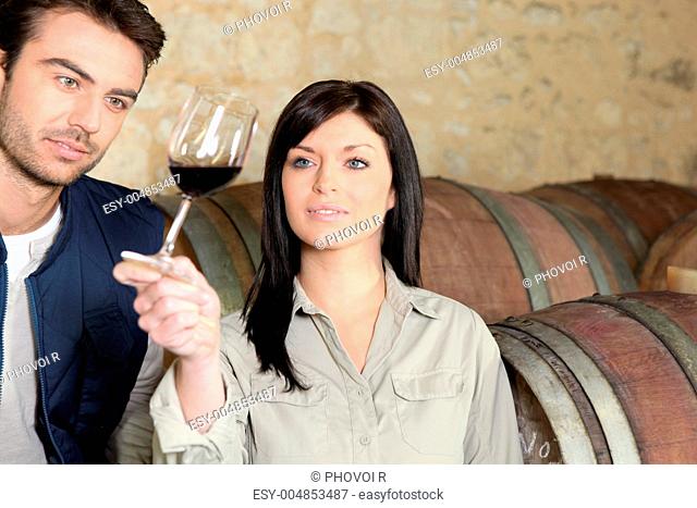 Couple in a cellar tasting wine