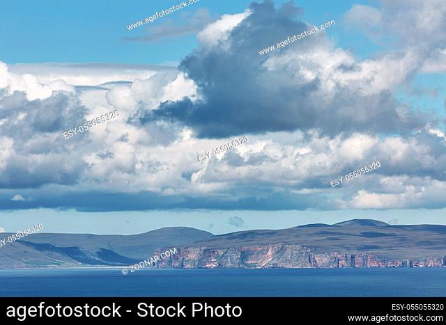 Orney cliffs with dramatic sky seen from John o'Groats over Atlantic ocean