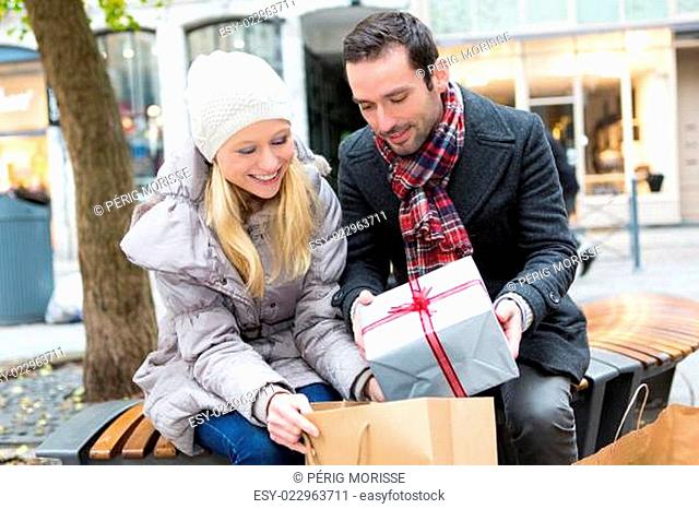Young attractive couple putting gift in bags
