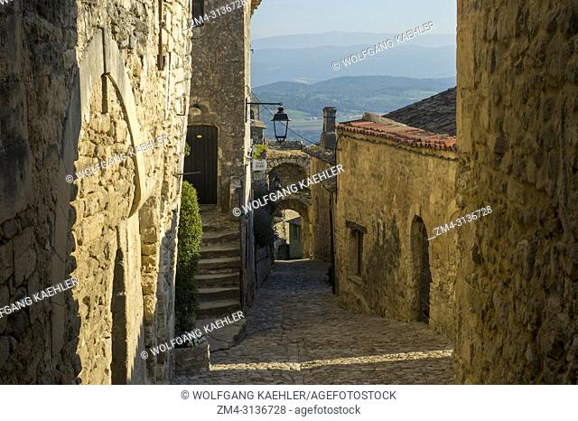 A gate and cobblestone street in the hillside village of Lacoste in the Luberon in the Provence-Alpes-Cote d Azur region in southeastern France