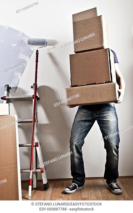 Man Carrying Stacked Boxes on moving day, desaturated image