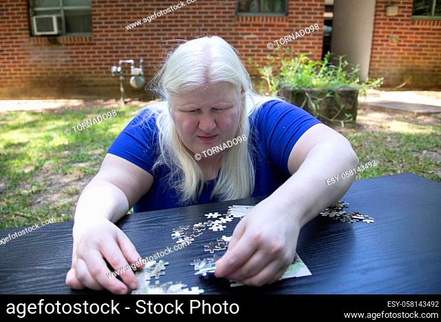 Woman placing a puzzle piece into the correct spot