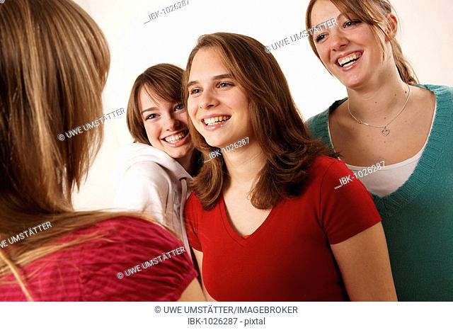 Four female teenagers laughing with one another