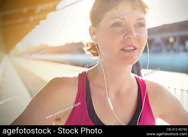 Close up confident young female runner with headphones