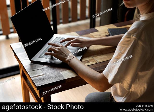 Woman's hands typing on laptop keyboard. Study and work online, freelance. Self employed or freelance woman, girl working with her laptop sitting at wooden...