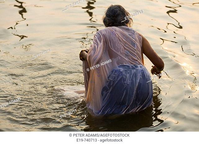 Female pilgrim bathing in the river Ganges at Kumbh Mela festival. Allahabad, Uttar Pradesh, India
