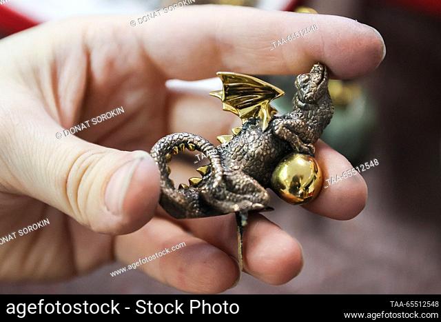 RUSSIA, YEKATERINBURG - DECEMBER 6, 2023: A worker demonstrates a bronze dragon at the Moiseikin jewellery house; the Chinese calendar names 2024 the Year of...