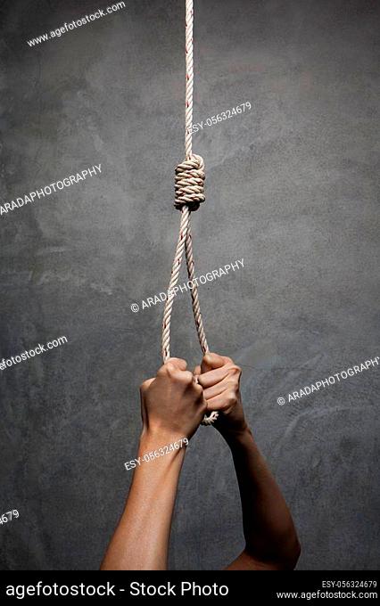 Hands holding rope slipknot in concept suicide