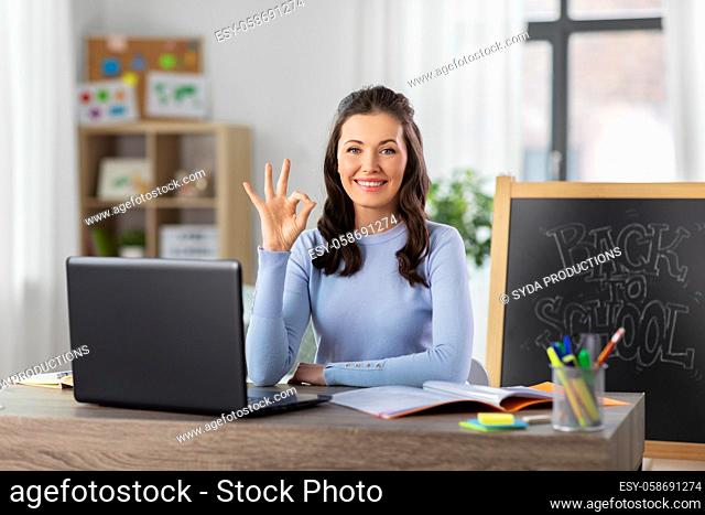 teacher with laptop and notebook working from home