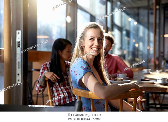 Portrait of smiling woman with friends in a cafe