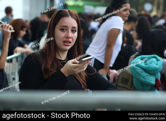 22 June 2023, Brazil, São Paulo: A young woman cries in front of the Allianz Parque stadium because she did not get tickets for ""The Eras Tour"" of Taylor...